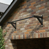 Zwarte pull-up bar gemonteerd aan buitenmuur met gemeleerde stenen voor outdoor training